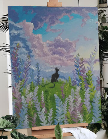 A black cat in a field of flowers looking over a cloud formation